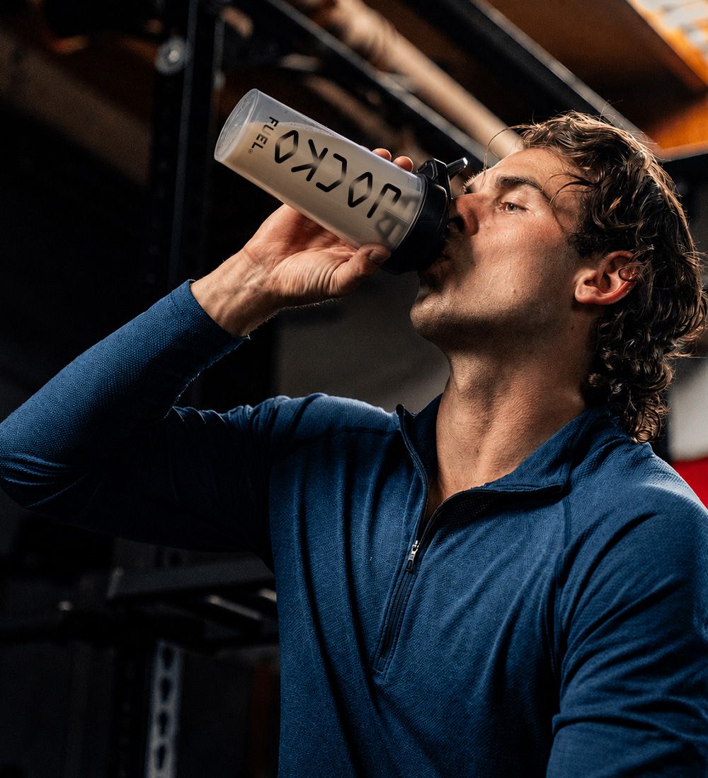 Athlete drinking from a Jocko Fuel shaker in the gym