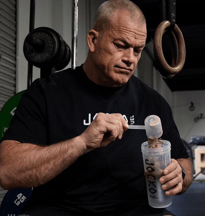 Jocko Willink scooping protein powder into a shaker