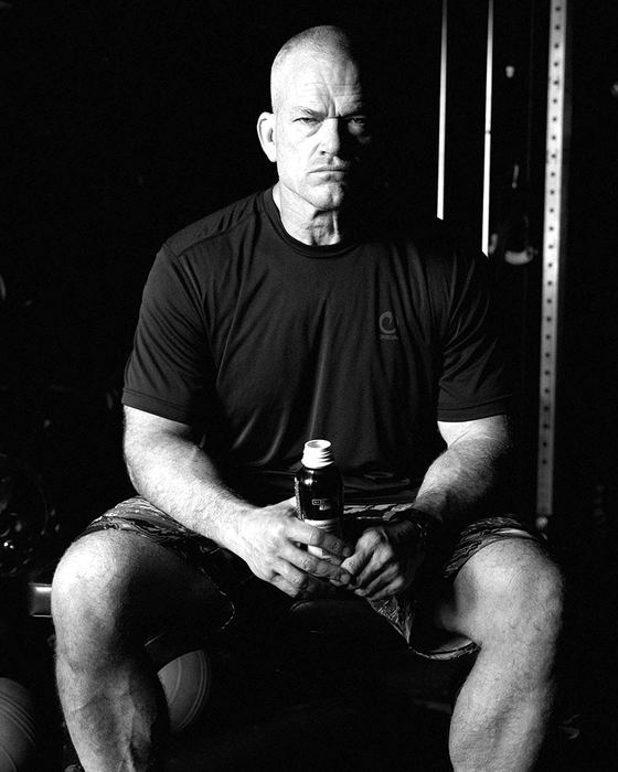 Jocko Willink seated in the gym holding a Jocko Fuel bottle