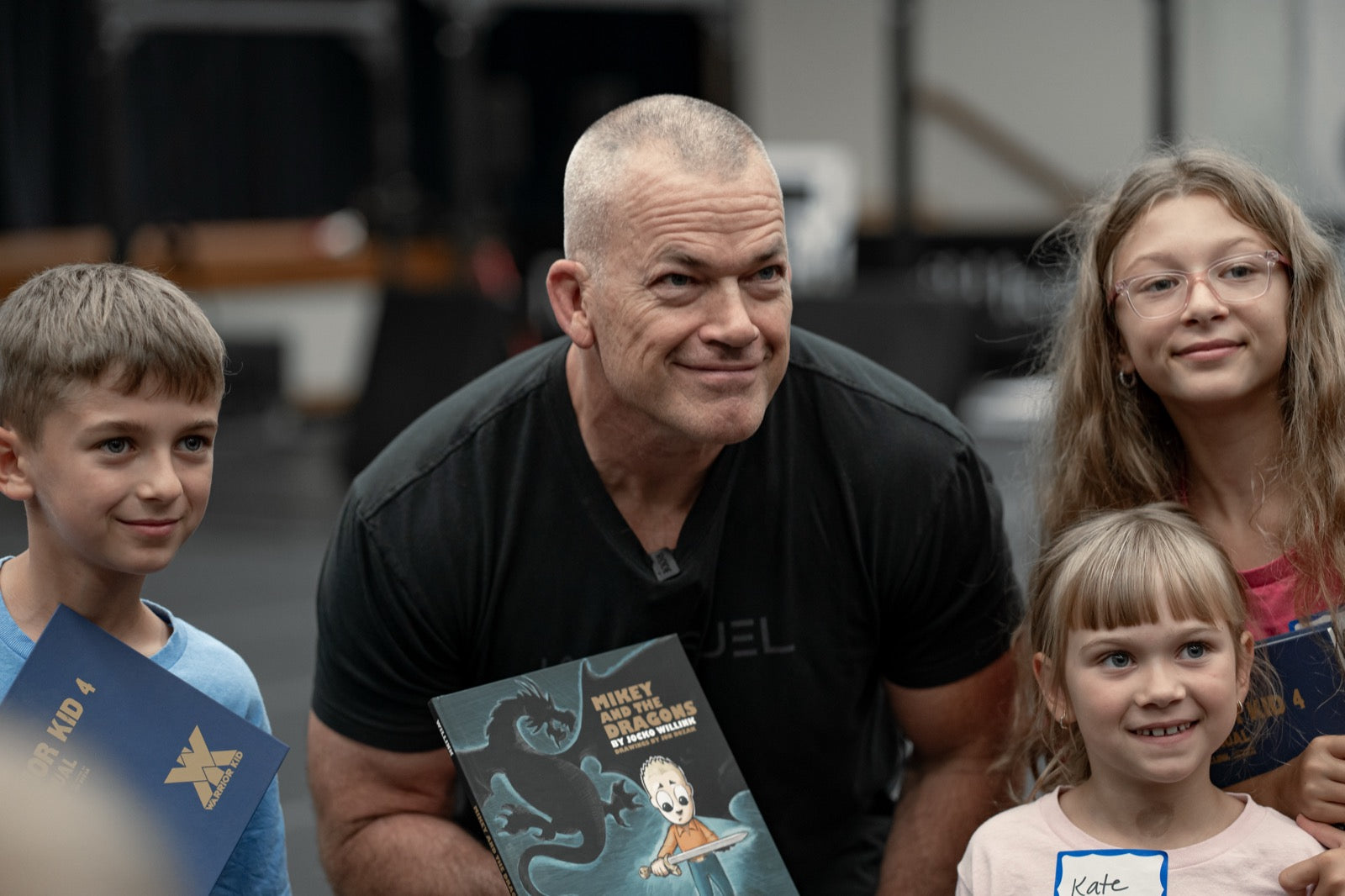 Jocko Willink kneeling with three kids holding Warrior Kid books