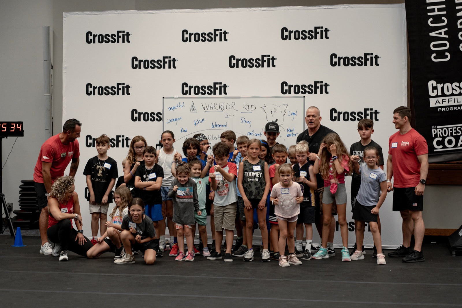 Jocko Willink and coaches lined up with a group of kids at a gym